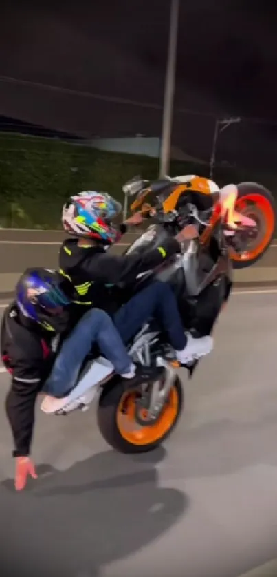 Motorcycle stunt at night with vibrant colors on a city road.