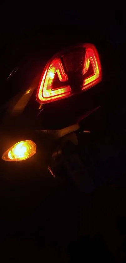 Glowing motorcycle tail light in dark.