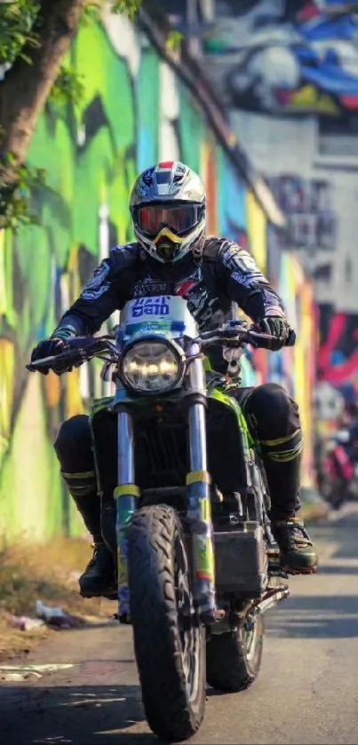 Motorcyclist rides through vibrant graffiti-lined urban street.