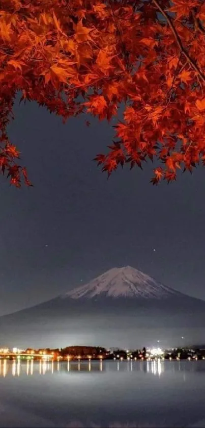 Mount Fuji at night with autumn leaves reflecting on a calm lake.