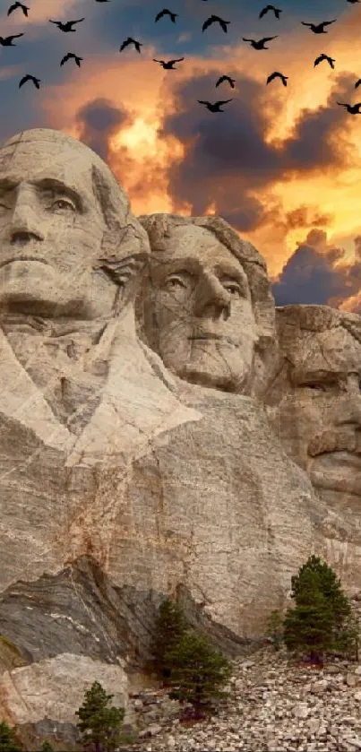 Mount Rushmore under vibrant sunset with dramatic sky and flying birds.