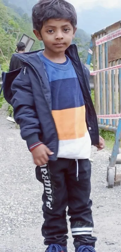 Child standing on a mountainside road in colorful attire.