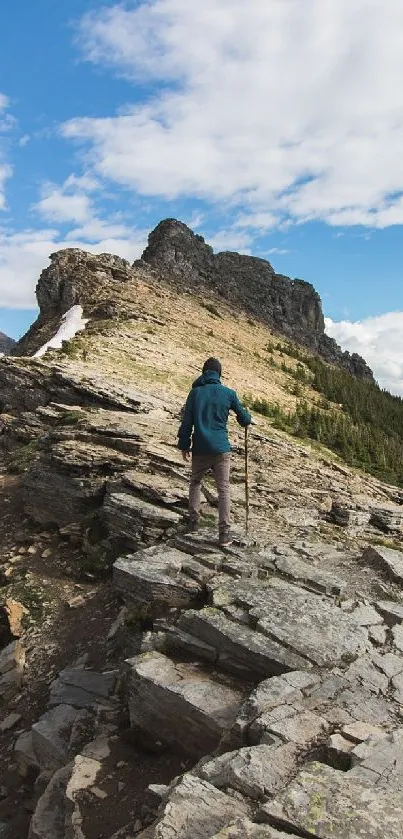 Hiker explores rocky mountain ridge under a blue sky.