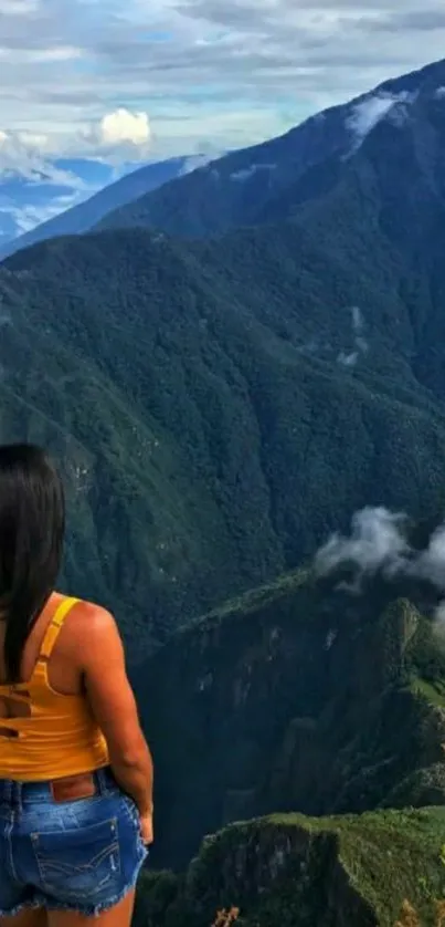 Traveler gazes at verdant mountain view, misty peaks in the background.