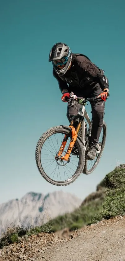 Cyclist jumping on mountain bike against clear sky.