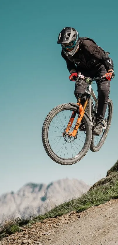 Mountain biker mid-air on a rugged trail with scenic background.