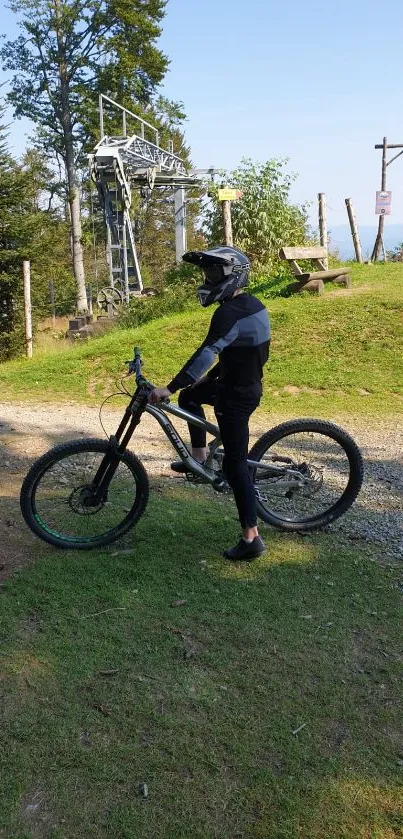 Mountain biker on trail in a lush green landscape.