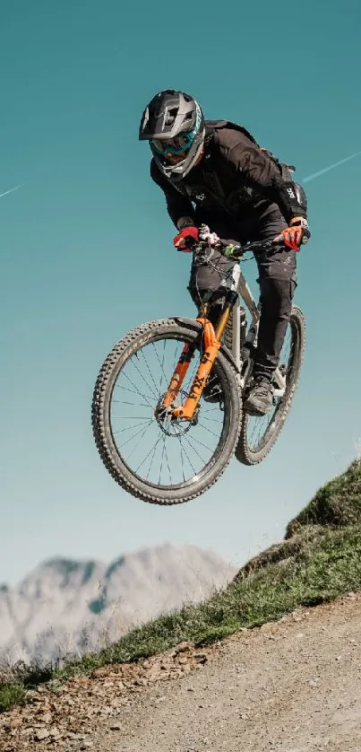 Mountain biker in mid-air against a teal sky, showcasing adventure and skill.