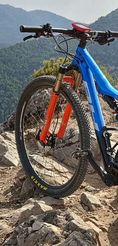 Mountain bike on rocky terrain with scenic mountain backdrop.