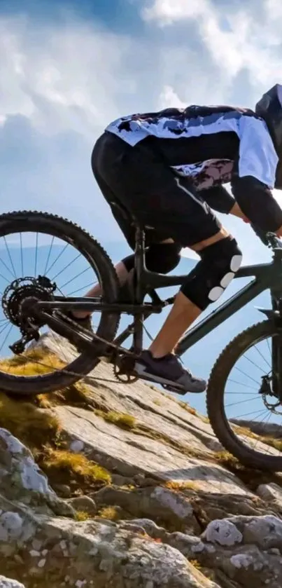 Cyclist biking on rocky terrain under blue sky.