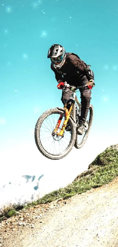 Cyclist performing a jump on a mountain trail with a blue sky backdrop.