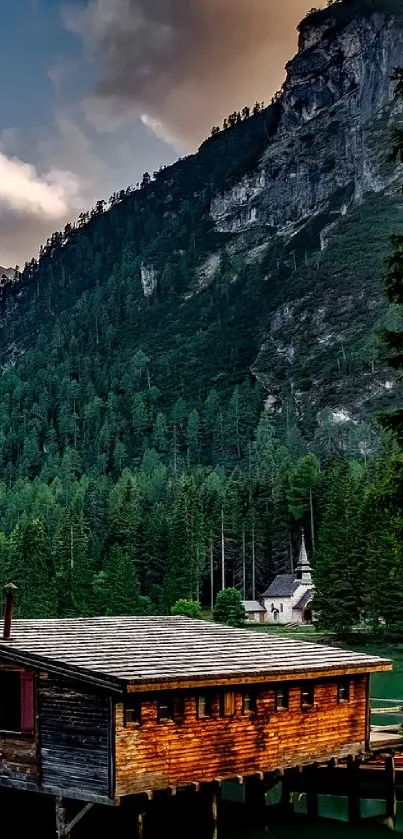 Wooden cabin by a mountain lake with lush green forest.