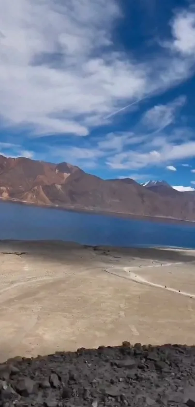 Scenic mountain lake with blue sky and clouds.