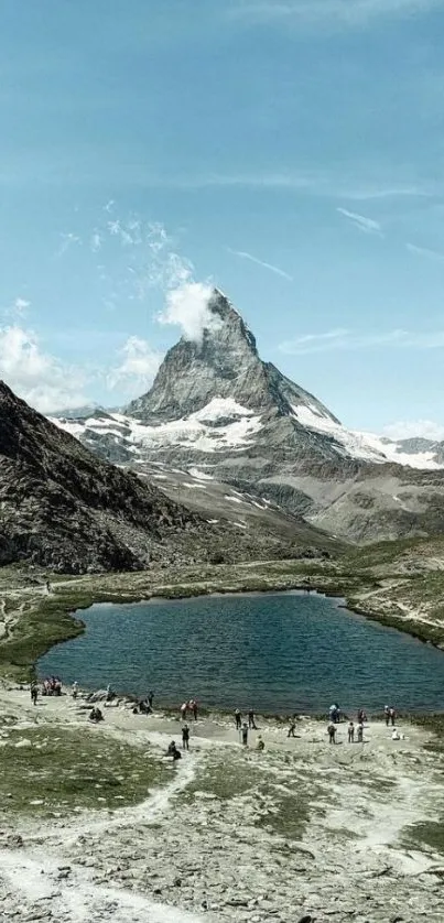 Majestic mountain peak and tranquil lake under a clear blue sky.