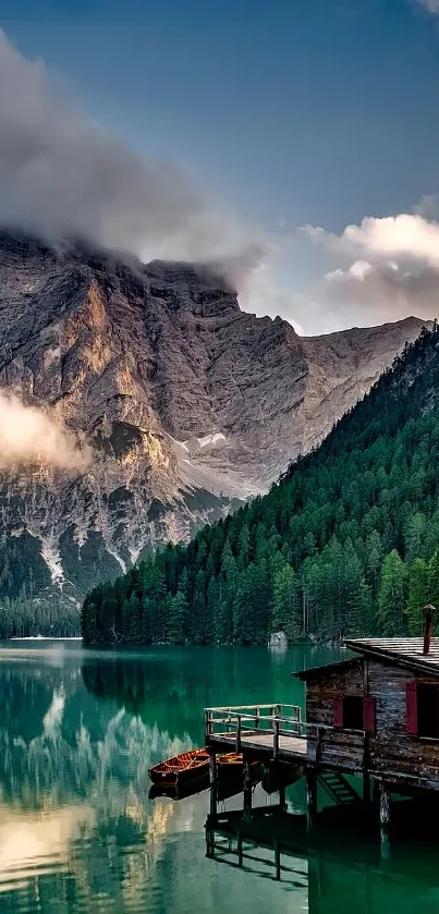 Wallpaper of a tranquil mountain lake with a rustic cabin and lush green forests.