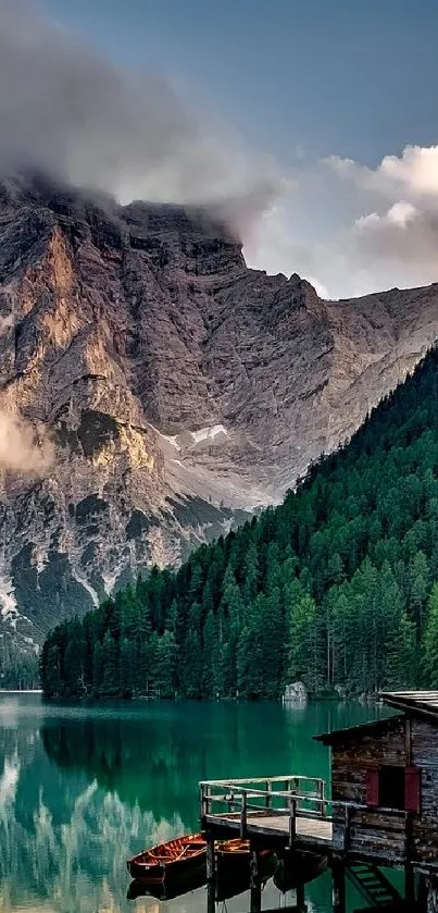 Serene mountain lake with lush green forest and cloudy peaks.