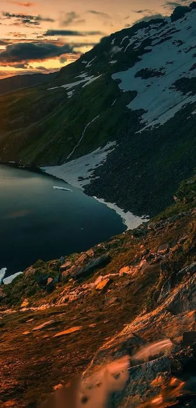 Sunset over a serene mountain lake with snow-capped peaks.