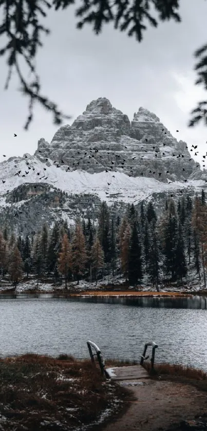 Snowy mountain with lake and trees in winter.