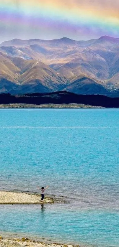 Mountain landscape with rainbow over a blue lake.