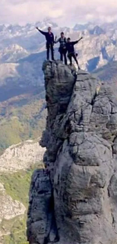 Climbers on a rocky mountain peak in stunning landscape.