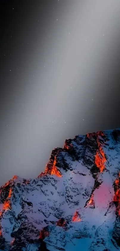 Snow-capped mountain peak under a starry night sky with glowing orange light.