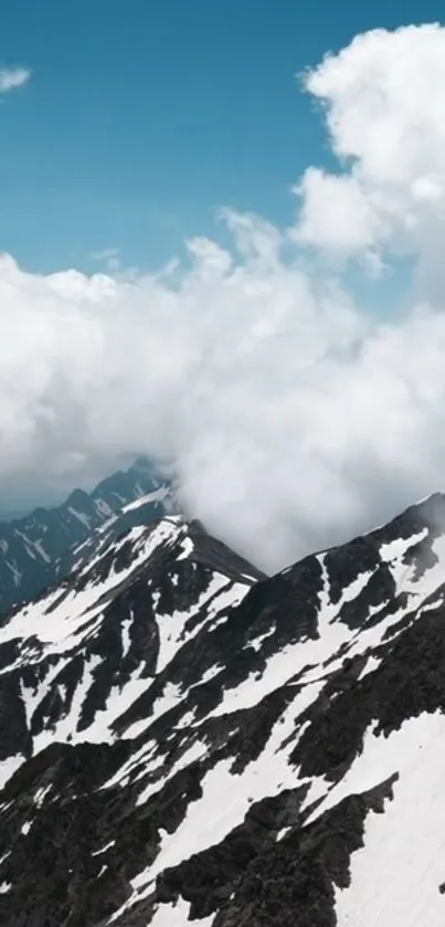 Snow-capped mountain peaks under fluffy white clouds.