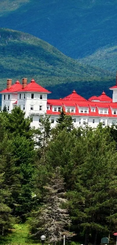 Scenic view of a red-roofed building nestled in lush green mountains.