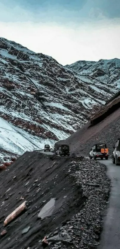 Off-road SUVs on snow-dusted mountain road, stunning landscape.