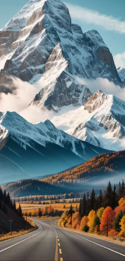 Scenic road with autumn trees and snow-capped mountains.