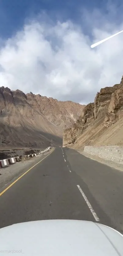 Scenic drive through mountainous landscape under a blue sky.