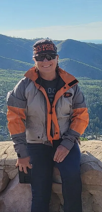 Person enjoying scenic mountain view with clear blue sky.