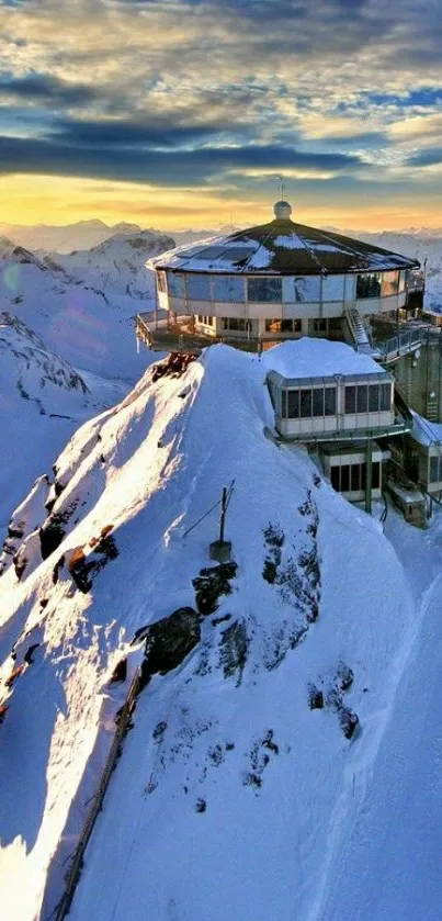 Chalet perched on snowy mountain at sunrise with vibrant sky.