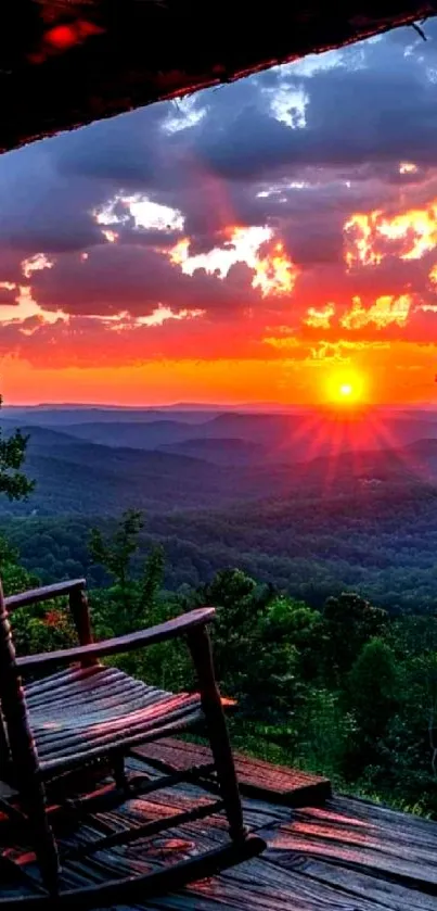 Mountain view at sunset with vibrant orange skies and a wooden chair on a porch.