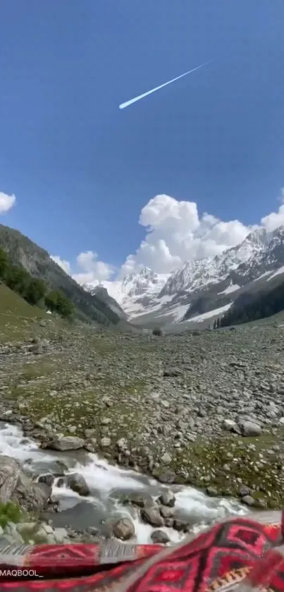 Scenic mountain valley with river, blue sky, and snow-capped peaks.