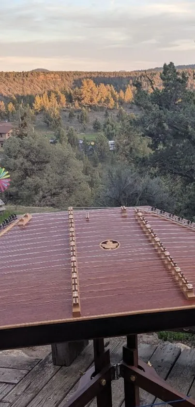 Rustic deck with zither and mountain view in sunset light.