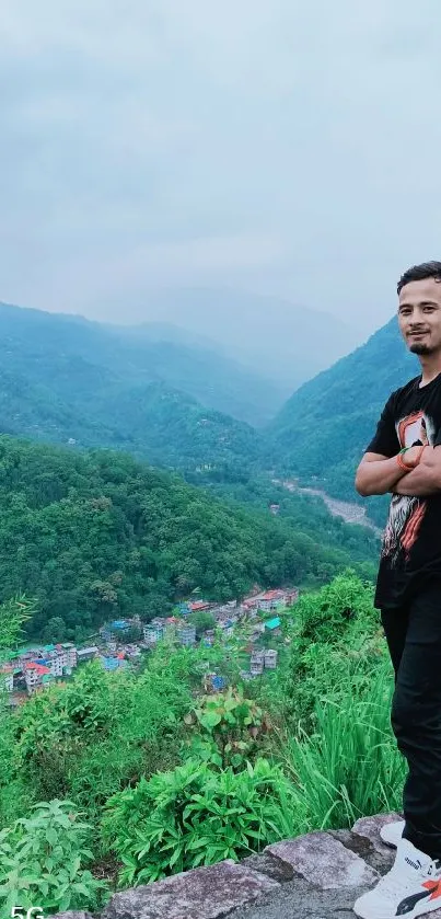 Man standing on mountain overlooking lush green valley.