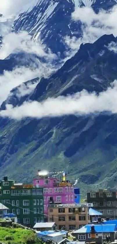 Quaint village against a lush mountain backdrop with clouds.