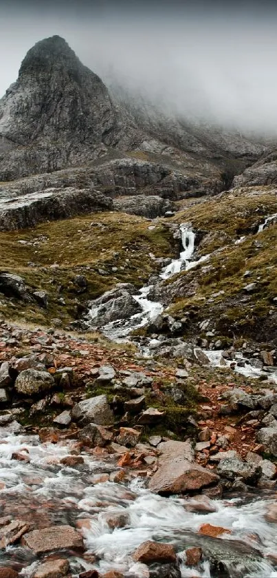 Misty mountain landscape with river flowing through rugged terrain.