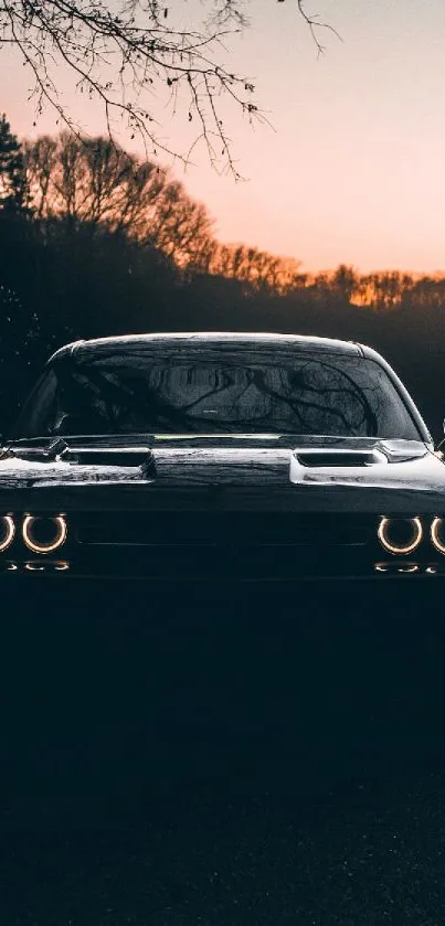 Sleek muscle car silhouette at sunset with glowing headlights.