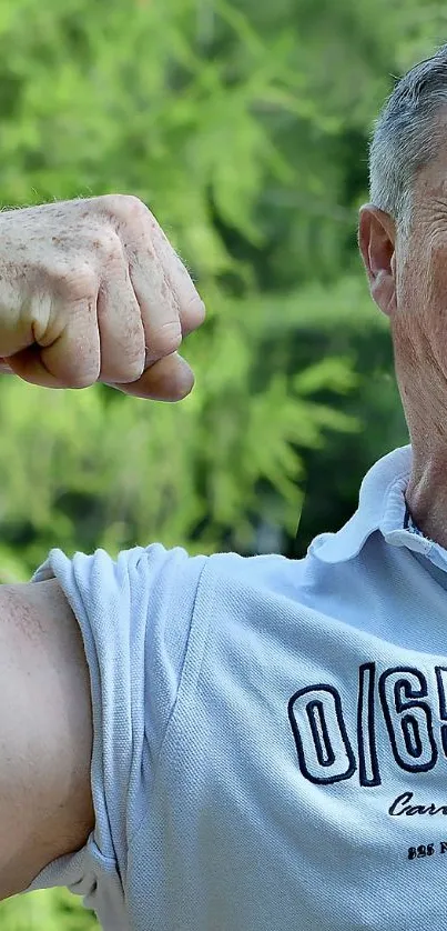 Man flexing muscles in forest setting.