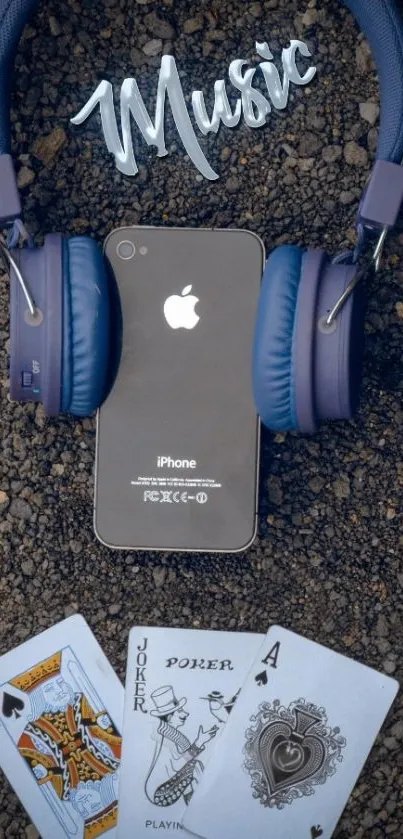 Dark blue headphones, cards, and phone with 'Music' text on gravel.