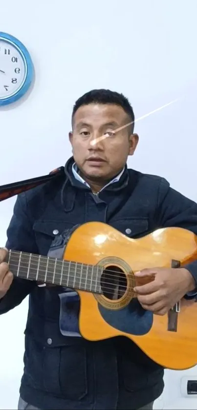 Man standing with a guitar and wall clock in the background.