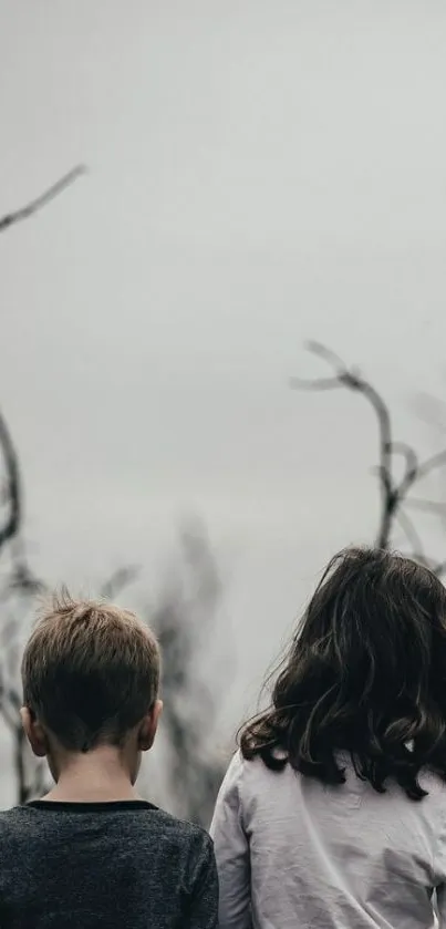 Two children silhouetted in a muted forest scene, embodying serenity and nature.