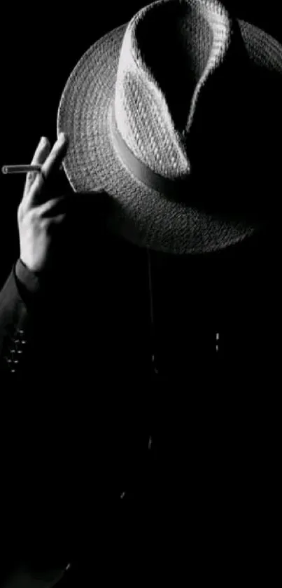 Silhouette with fedora hat in dark background.