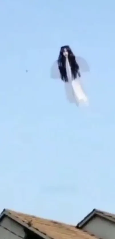 Mysterious floating figure against blue sky over rooftops.