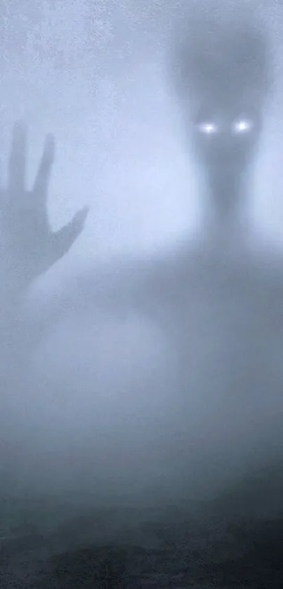 Mysterious foggy wallpaper with spectral figure and glowing eyes.