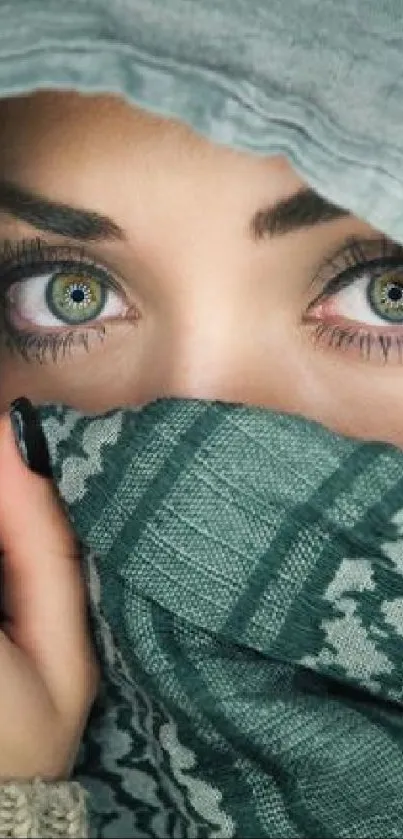 Captivating green eyes hidden behind a patterned grayish-green scarf.