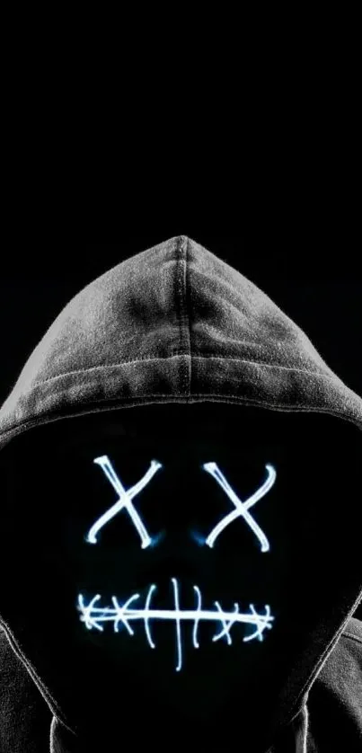 Hooded figure with glowing face design on black background.