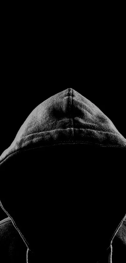 Mysterious hooded figure on a black background for mobile wallpaper.