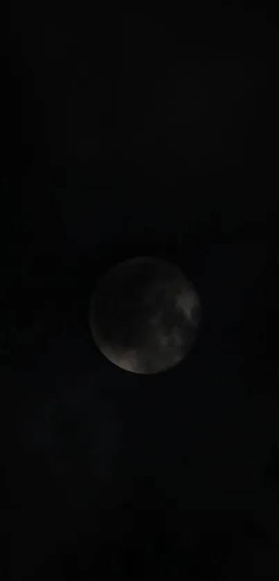 A dark, mysterious moon during an eclipse set against a black night sky.